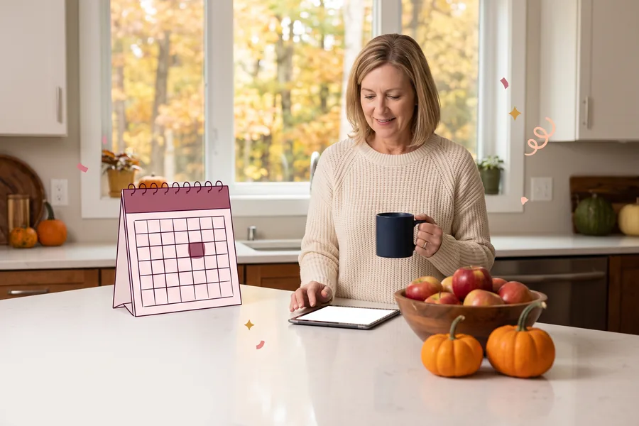 Woman at a kitchen island reviewing a list on a tablet, apples and pumpkins on the counter