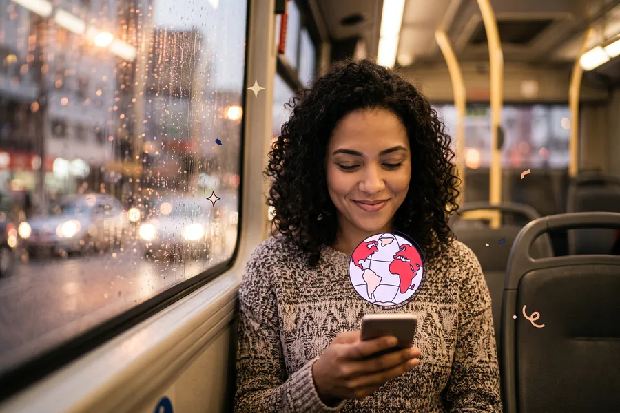 Woman on a city bus in the evening, smiling at her phone