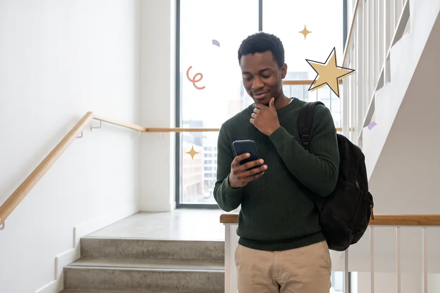 Man on a stairwell landing reading a message on his phone