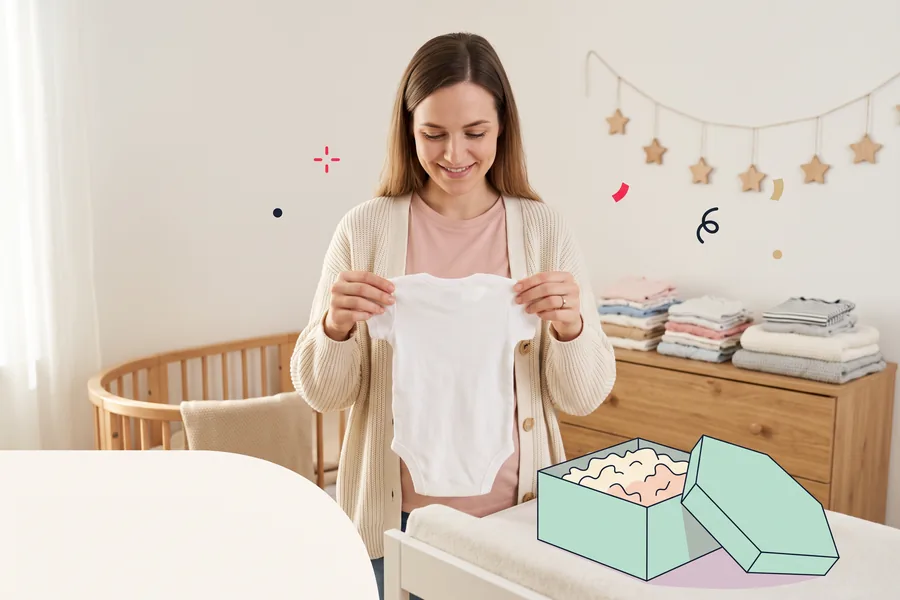 Woman in a nursery holding up a tiny onesie beside a bassinet