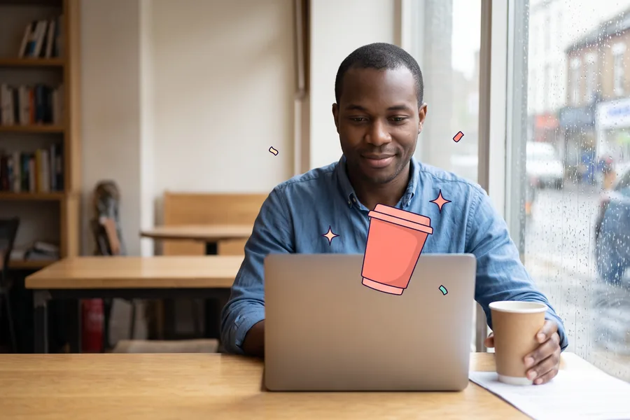 Sales rep working on a laptop at a cafe table by a rainy window