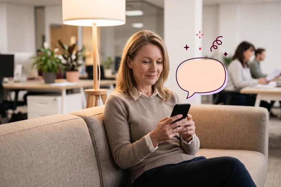 Woman on an office couch typing a short thank-you note on her phone