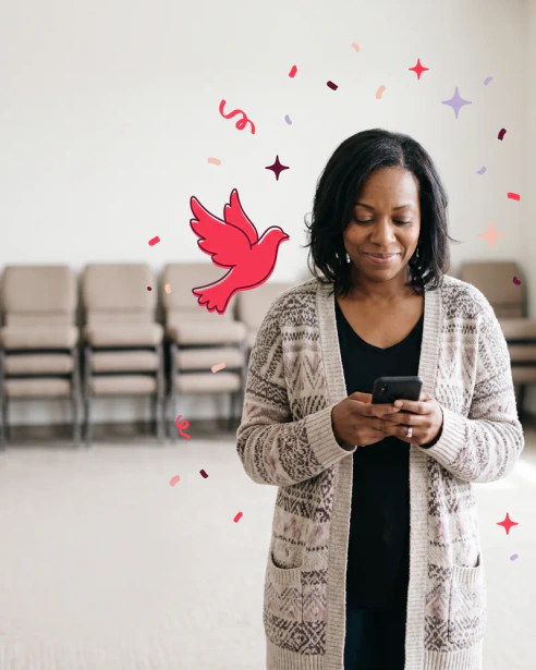 Church staff member in a church hall with stacked chairs, reading her phone