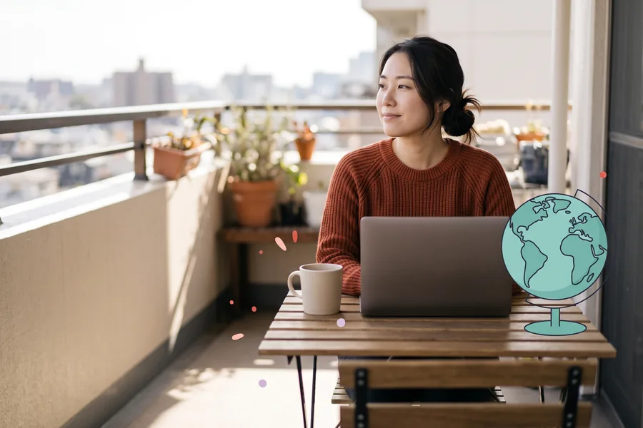 Woman relaxing at a small balcony desk with her laptop closed beside her mug