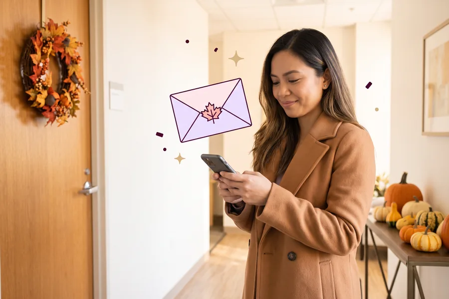 Woman in an office lobby decorated with pumpkins and autumn leaves, smiling at her phone