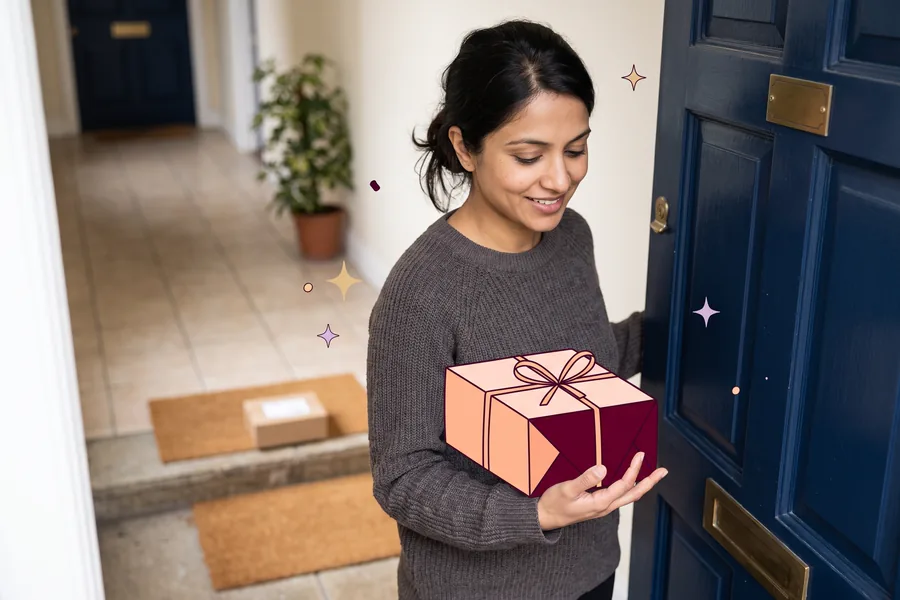 Woman opening her apartment door to find a small parcel on the step