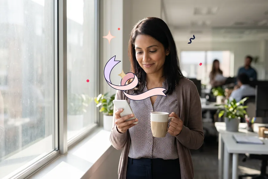 Woman at an office window with a coffee, reading a gift link on her phone