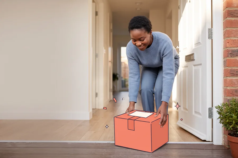 New hire at her front door lifting a welcome parcel from the step and reading the note