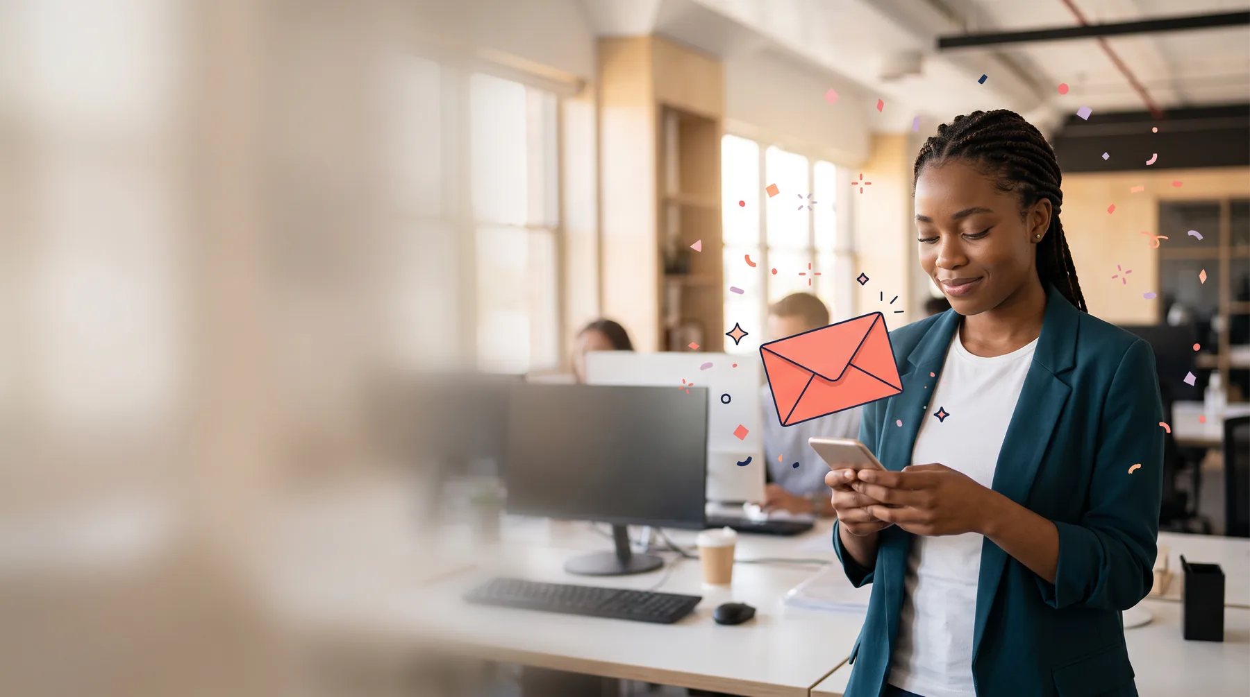 Intern in an open-plan office smiling at a gift on her phone